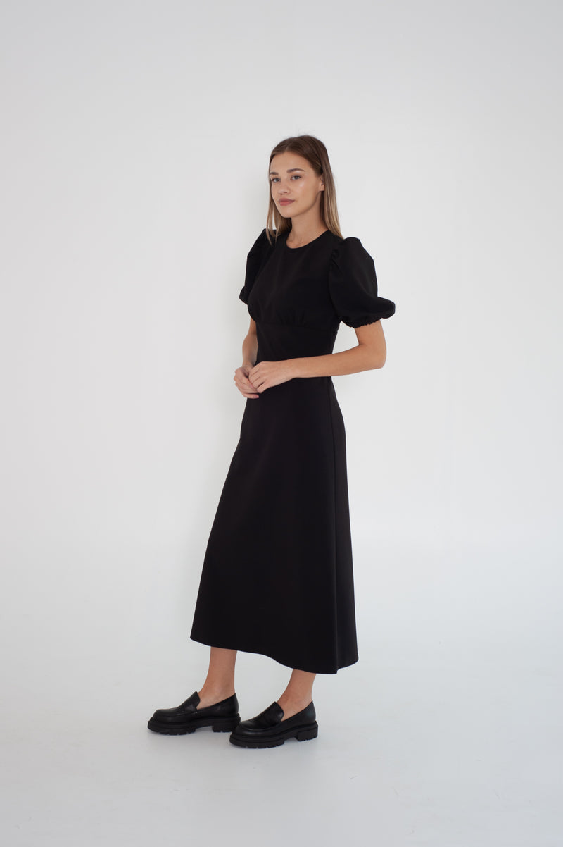 black midi dress with puff short sleeves from the side. Model wears size S.