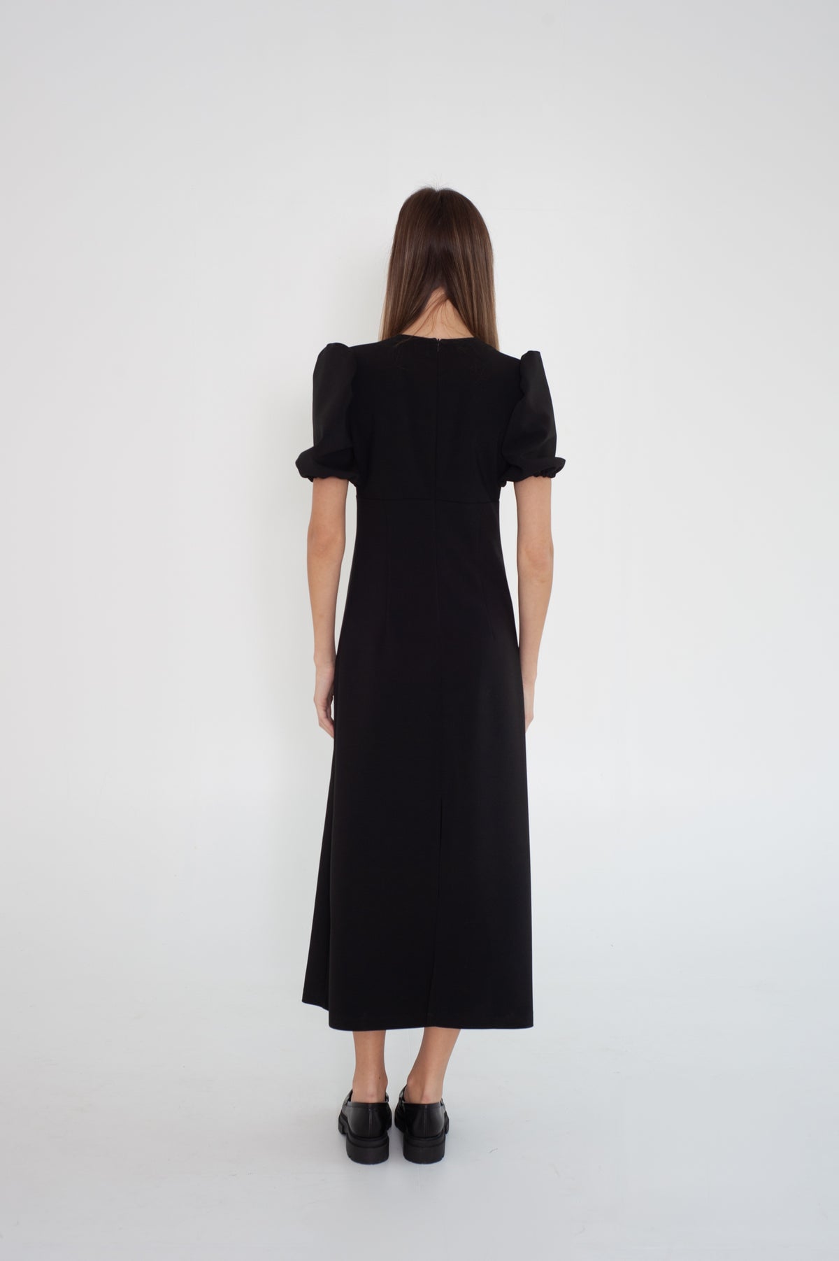 black midi dress with puff short sleeves from the back, shows well hidden back zipper. Model wears size S.