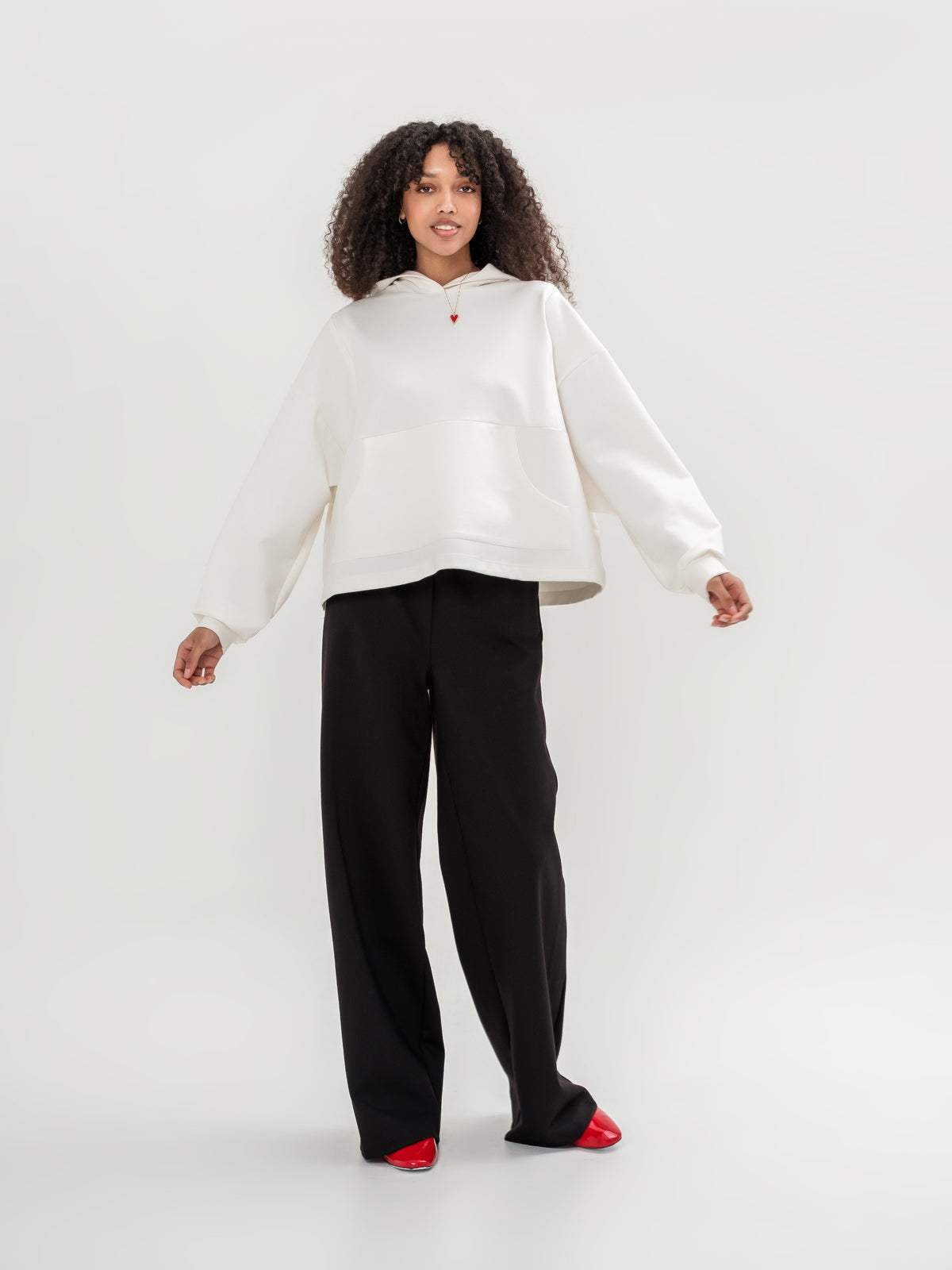White hoodie with zip shoulder area on the back and black wide leg trousers
