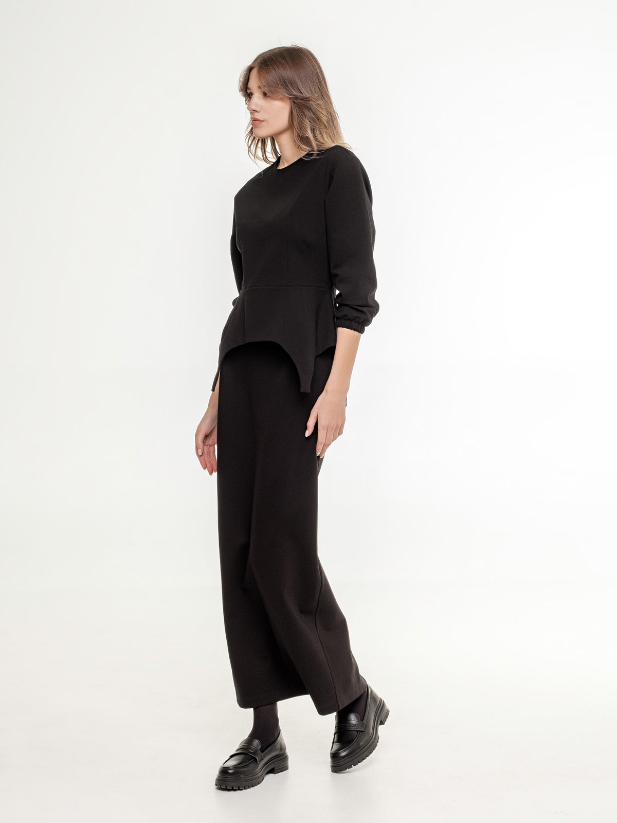 black feminine top with long black A shaped skirt view from the side 