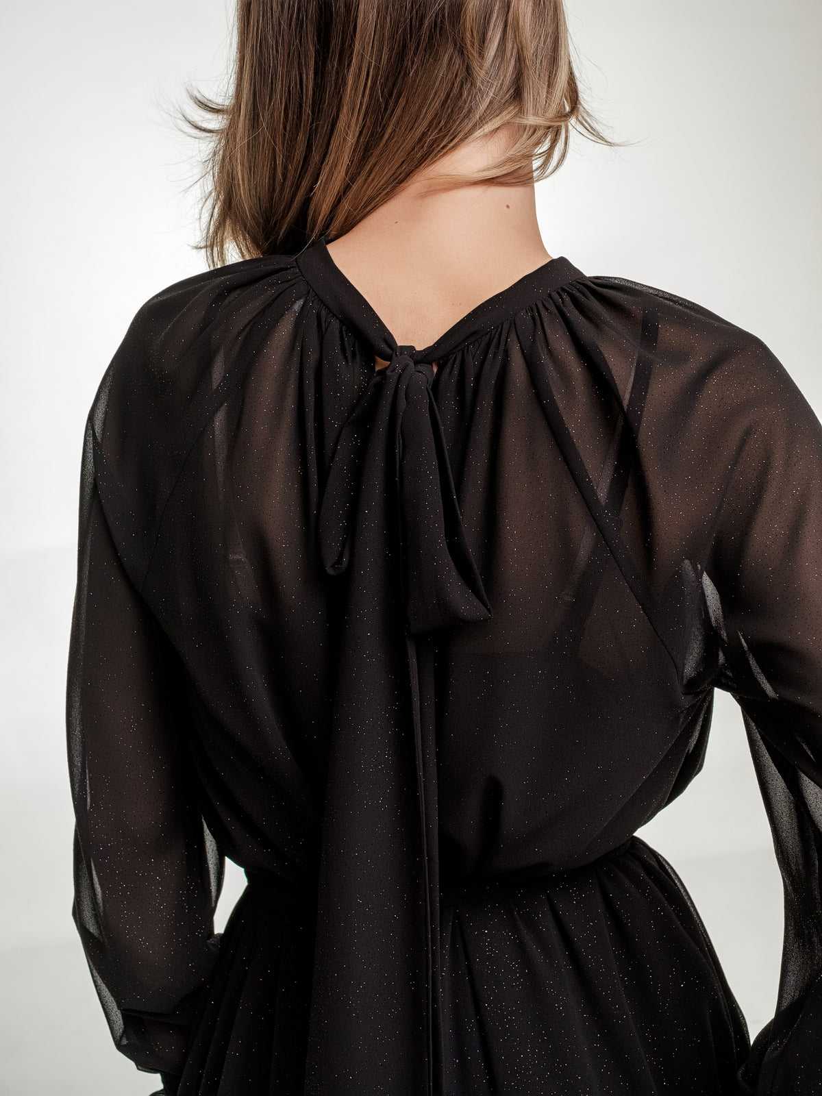 black midi dress with long transparent sleeves zoomed in back with bow 