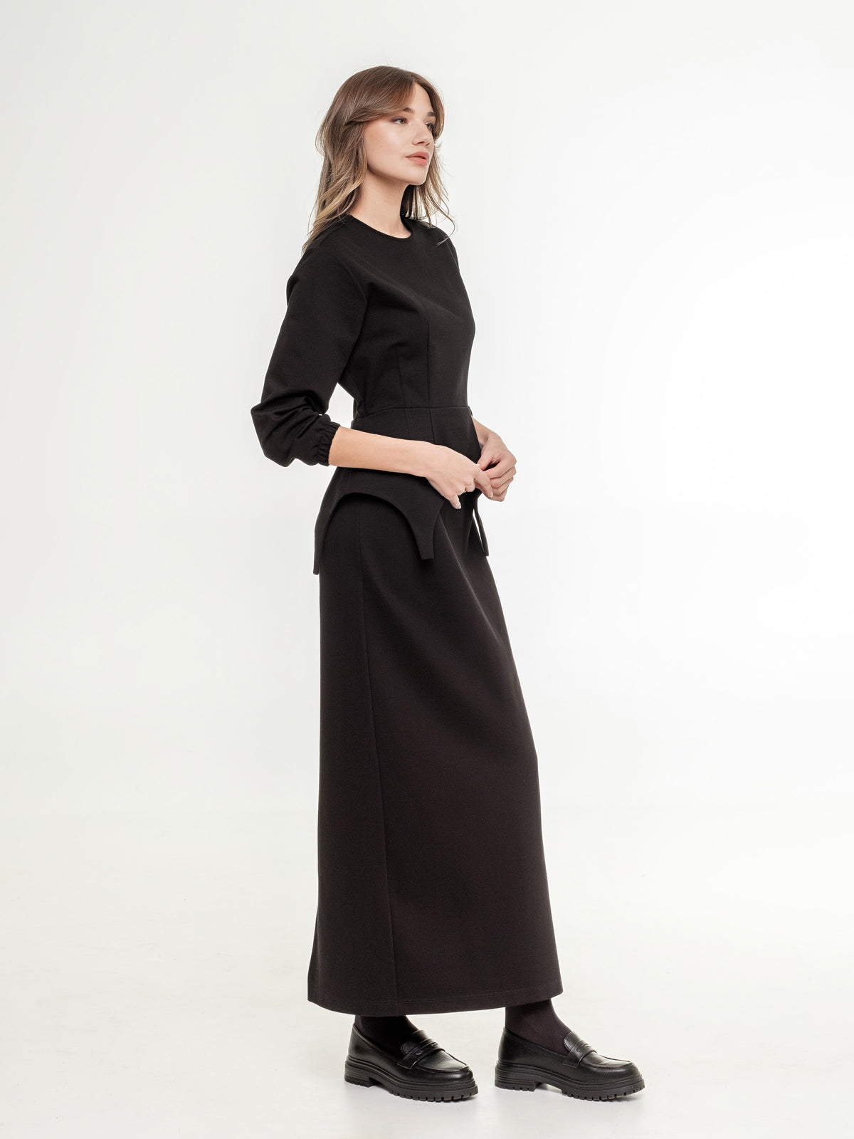 black set of top with long sleeves and A shaped long skirt from the side