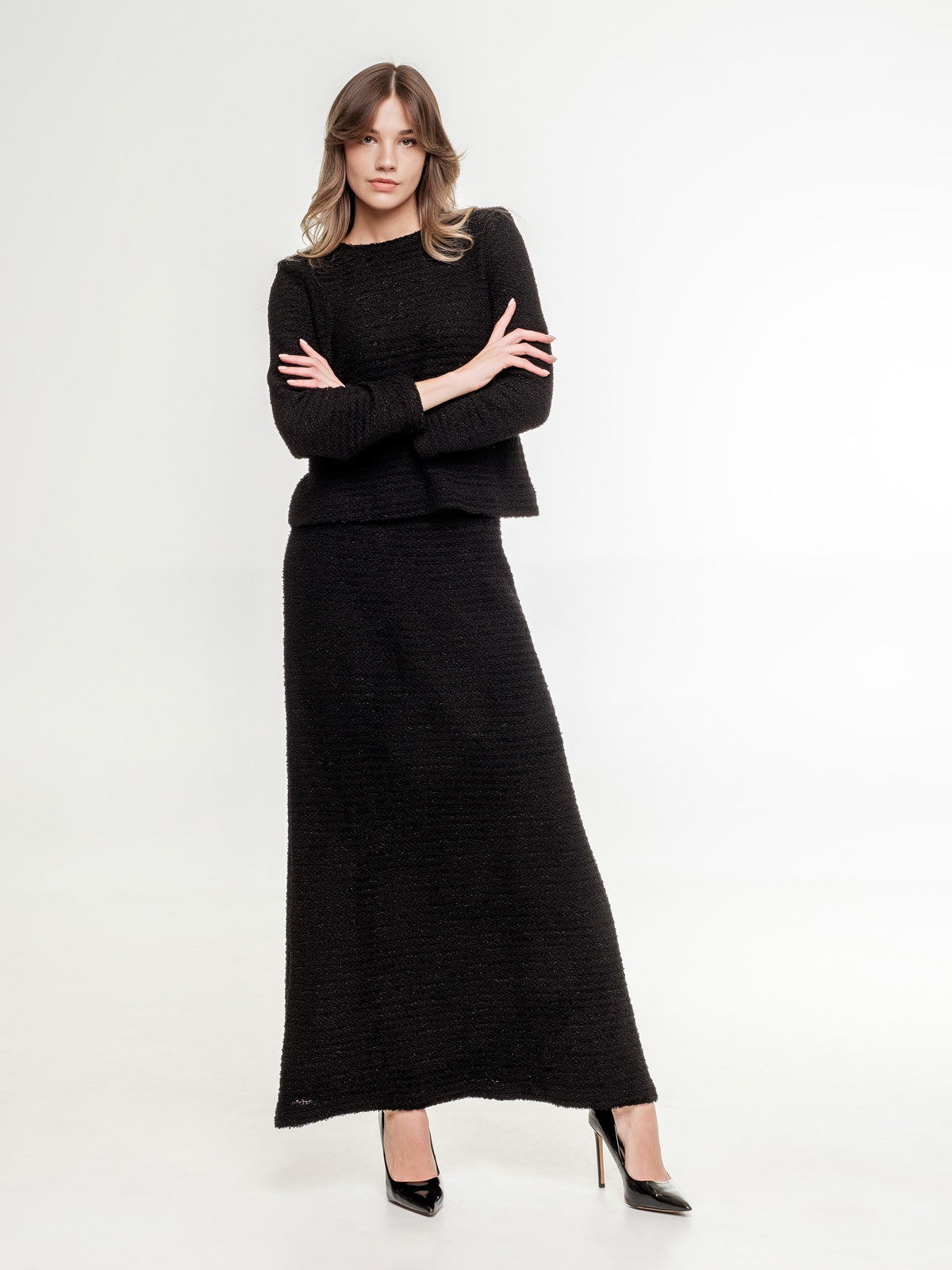 black_textured_top_with_long_sleeves and long skirt on the model