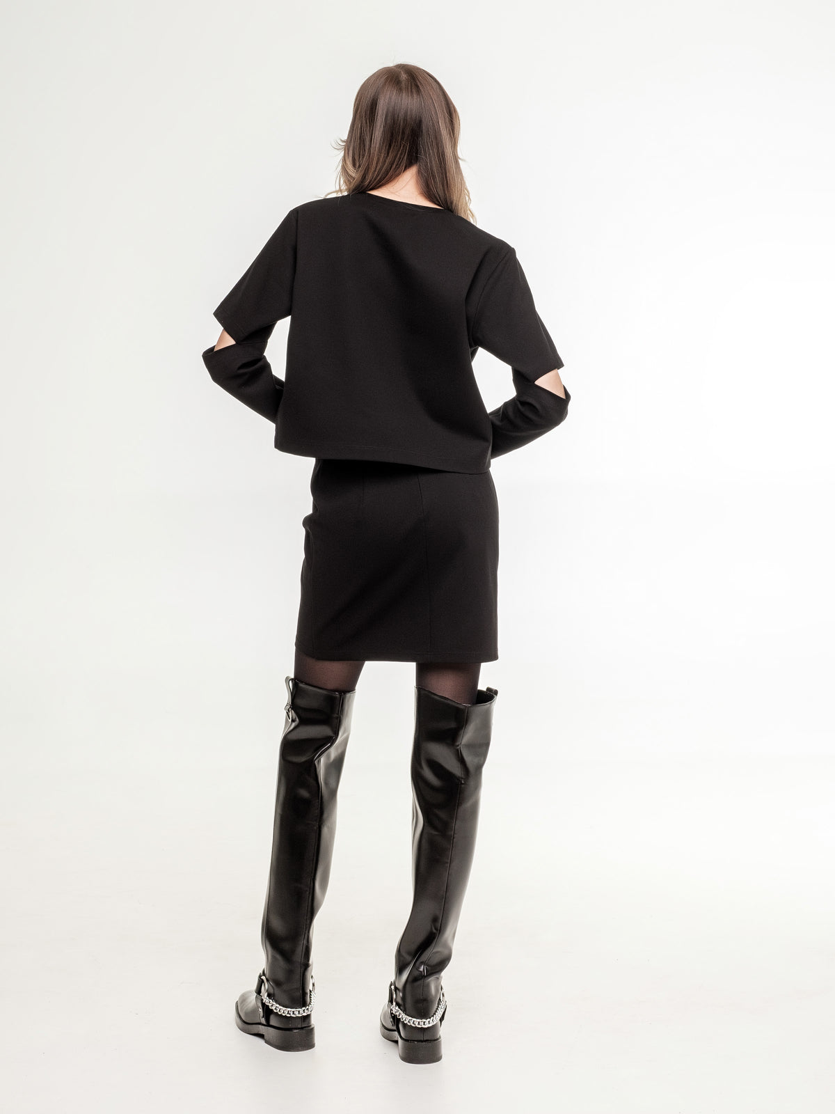 black top with long sleeves elbow cuts  and mini black skirt from the back