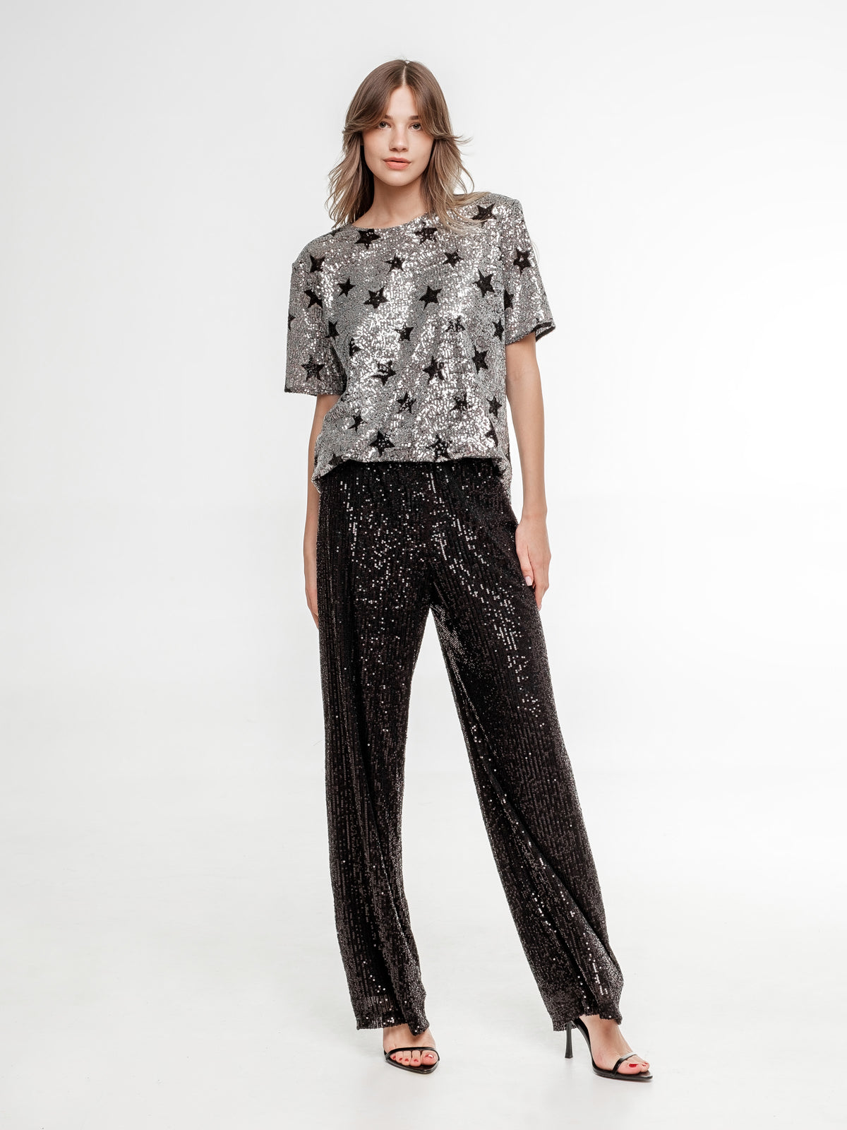silver glitter top with stars and black glitter wide pants full view