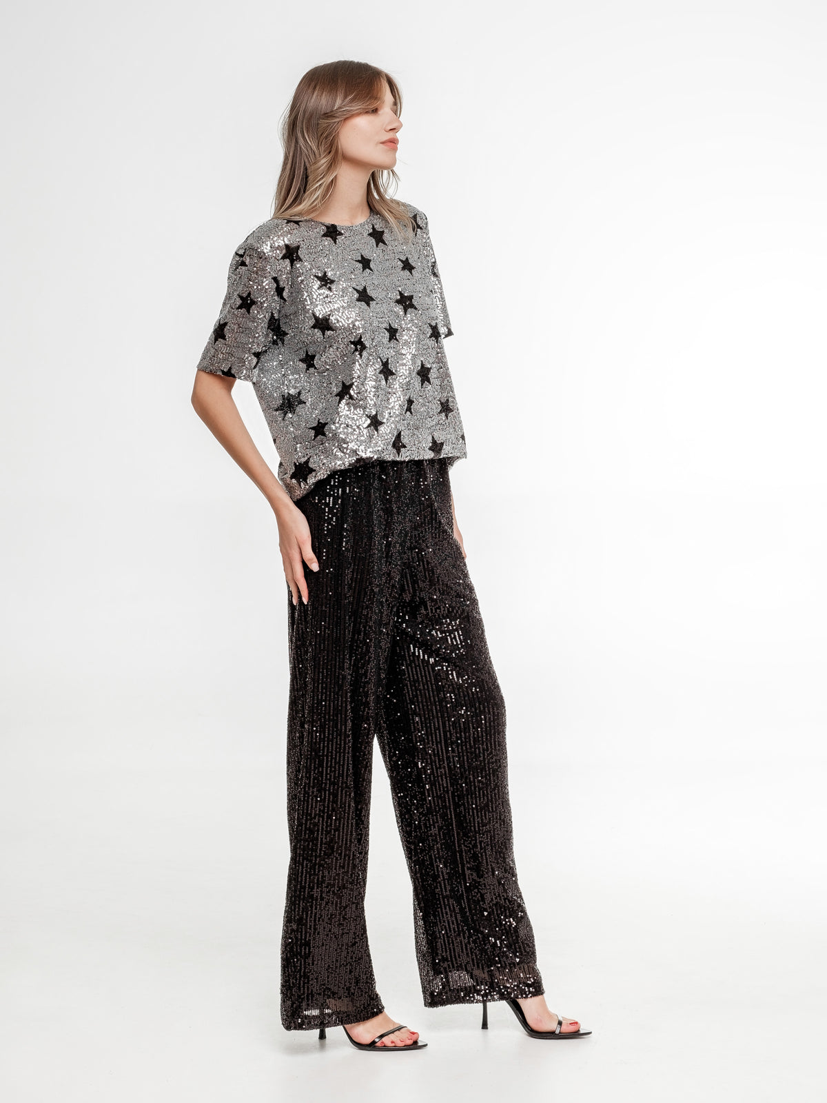 silver glitter top with stars and black glitter wide pants side view