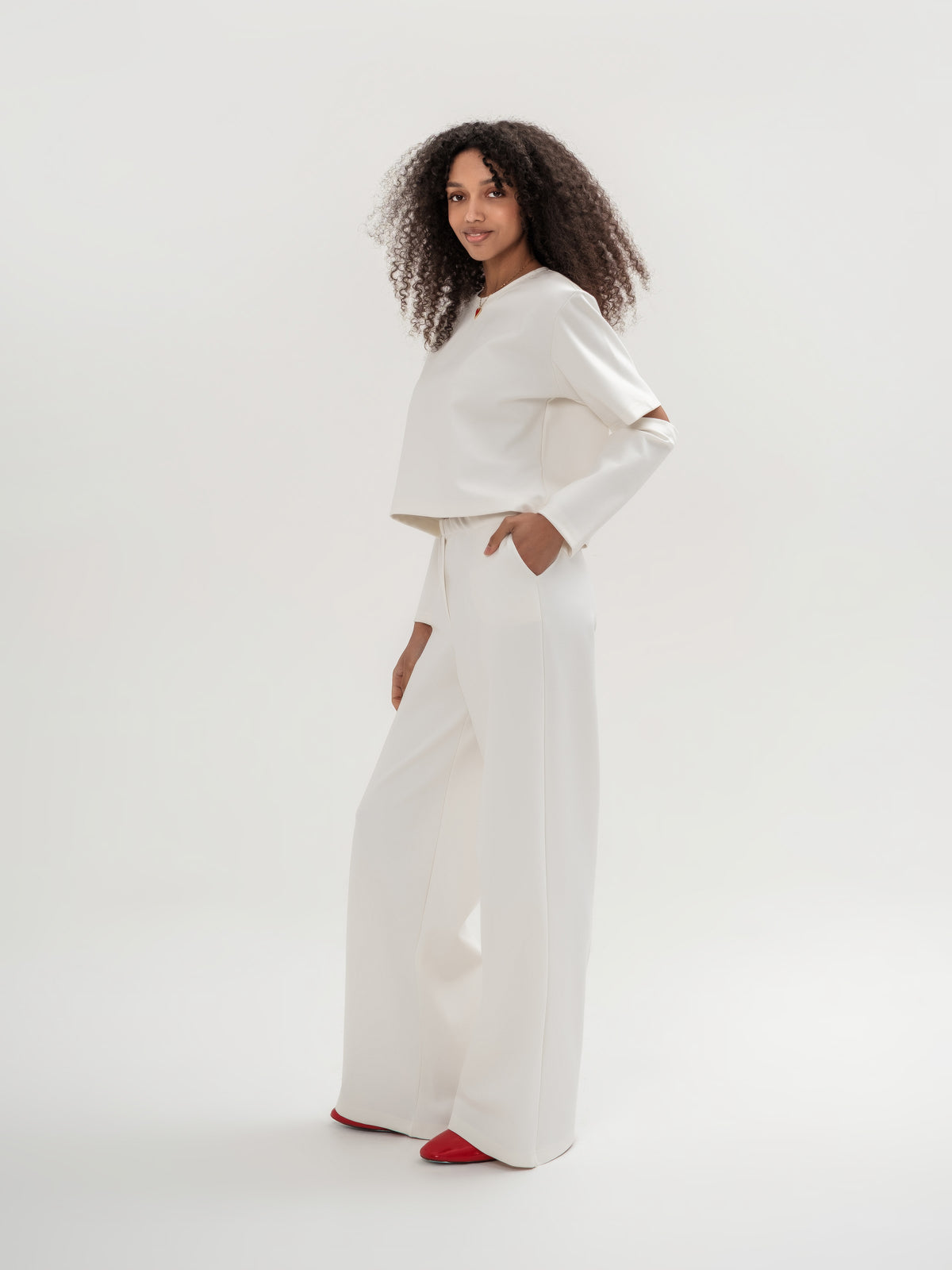 White wide leg trousers and white top with slits in the elbow area