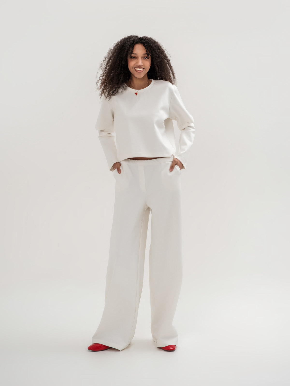 White wide leg trousers and white top with slits in the elbow area