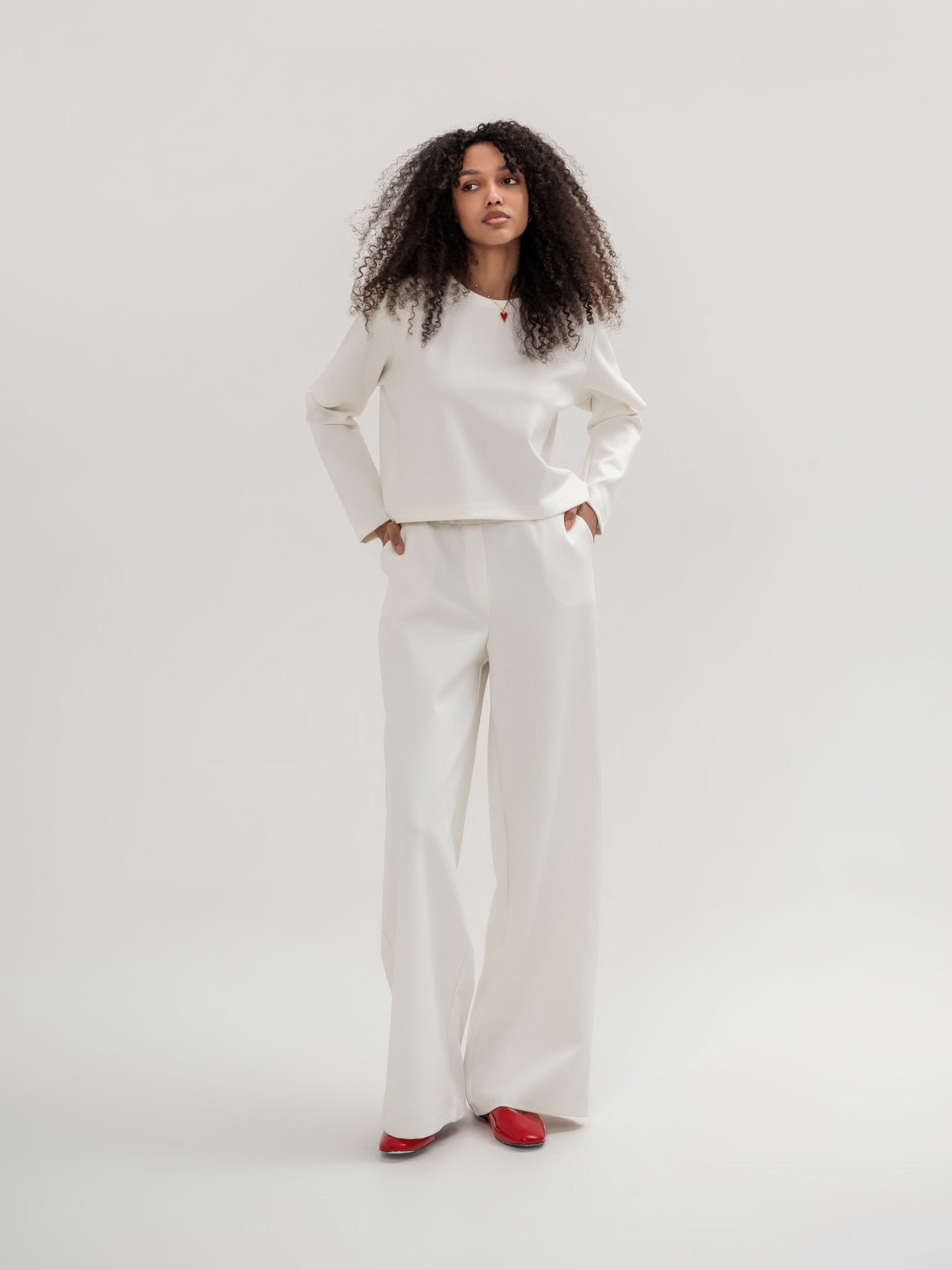 White wide leg trousers and white top with slits in the elbow area